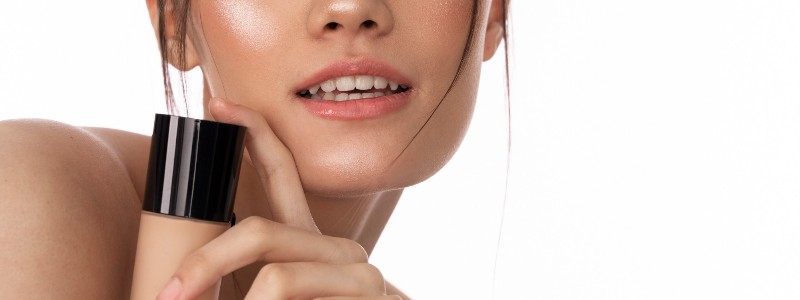 mujer agarrando base de maquillaje